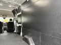 Interior of a 2020 Ford Transit van showing a spacious cargo area with black walls and flooring designed for storage and transport