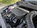 Close-up of the engine compartment of a 2024 Kia Forte5 highlighting the black engine cover and various connected components
