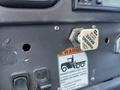 Close-up of the dashboard of a 2007 Freightliner M2 106 showing a parking brake release knob and a warning label about securing parked vehicles