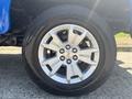 A silver alloy wheel with a Chevrolet emblem mounted on a black tire on a 2017 Chevrolet Colorado