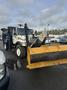 A 2007 International 7300 truck equipped with a large yellow snow plow attached to the front