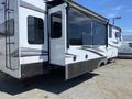 A white 2021 Grand Design Recreational ST3478MBS with slide-out sections featuring large windows and decorative side stripes
