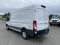 A white 2024 Ford Transit van viewed from the rear with a high roof and sliding side door