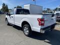 White 2018 Ford F-150 with a cargo bed and a box mounted in the back, featuring chrome wheels and a sleek body design