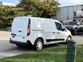 A white 2020 Ford Transit Connect van parked with a sliding side door and rear doors visible on the driver side
