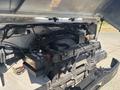 A 2012 Ford E-450 engine compartment showing the engine, battery, and various components with wires and hoses visible