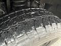 Close-up view of a 2008 Ford F-250 SD tire showcasing its tread pattern and texture with visible water droplets on the surface
