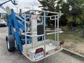 A blue Genie TZ-34/20 aerial lift with a metal platform and safety railing designed for reaching heights in construction and maintenance tasks