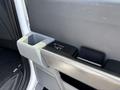 Interior view of a 2021 Ford F-150 door panel featuring a cup holder and a power window control button