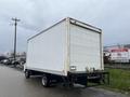 A white 2012 Mitsubishi Fuso FE box truck is parked with its rear visible showing a plain exterior and no additional markings