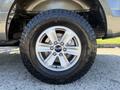 A close-up of a 2018 Ford F-150 wheel showcasing a silver alloy rim and a dark rugged tire with prominent treads