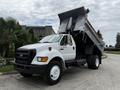 A white 2004 Ford F-750 dump truck with the dump bed raised showcasing its capacity for loading and transporting materials