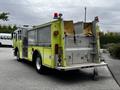 A yellow and silver 1995 Freightliner FLL086 fire truck with various compartments and a mounted light on the roof
