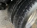 Close-up of two tires from a 2015 Ford F-550 showing deep treads and shiny rims