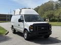 A 2008 Ford Econoline van with a high top roof and black front grille parked on a driveway