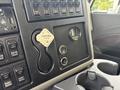 Interior dashboard of a 2013 International WorkStar showing buttons gauges and a parking brake tag