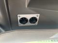 Two control knobs mounted on a square panel in a vehicle interior designed for adjusting settings like lighting or ventilation