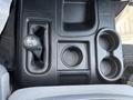 Overhead view of the center console in a 2013 RAM 2500 showing the gear shift lever a small storage area and two cup holders