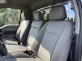 Interior view of a 2022 Ford F600 showcasing gray fabric seats with headrests and safety belts in a spacious cab layout