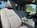 Interior of a 2022 Ford F600 showcasing the front seats with a fabric upholstery in grey and a spacious seating layout