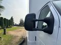 A side mirror of a 2008 Ford Econoline van with a black casing and a clear reflective surface