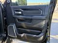Interior door panel of a 2021 RAM 3500 featuring black leather upholstery with chrome accents and a large handle