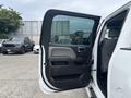 A 2016 GMC Sierra 1500 with the driver's side door open showing the interior door panel and armrest