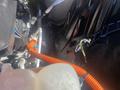 A close-up view of the engine compartment of a 2020 Ford Explorer featuring visible components such as hoses and wiring with an orange conduit running alongside