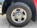 Close-up of a shiny chrome wheel with a rugged all-terrain tire mounted on a 2013 RAM 2500