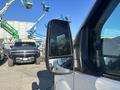 A 2017 Ford Transit-350 with a focus on its side mirror reflecting the surroundings
