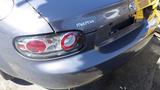 A rear view of a gray 2007 Mazda Miata showcasing its taillights and brand emblem