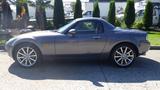 A silver 2007 Mazda Miata with a convertible top and alloy wheels parked on a driveway