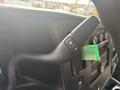 A close-up view of the steering wheel controls in a 2021 Chevrolet Express featuring a toggle switch with plus and minus symbols for adjusting settings