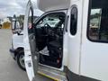 A 2020 Chevrolet Express van with an open driver's side door exposing the interior and dashboard