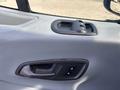 The interior door panel of a 2016 Ford Transit 150 featuring a door handle and control buttons for window operation