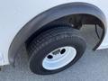 Close-up of the rear tire of a 2012 Ford Econoline showing a black rubber tire with a tread pattern and a metal wheel rim