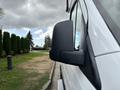A side view of a 2020 Mercedes-Benz Sprinter 2500 showing the black side mirror and part of the vehicle's white body
