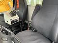 Cab interior of a 2016 Freightliner 108SD featuring two black seats and a control panel with multiple levers and buttons