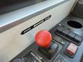 A close-up of a control panel featuring a prominent red lever with a textured grip and directional labels indicating applied and released positions