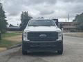A 2023 Ford F-450 Super Duty with a white exterior visible from the front showcasing its bold grille and distinctive headlights