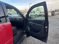 A red 2011 Chevrolet Avalanche with its front door open revealing the interior and dashboard details