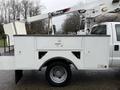 A 2012 Ford F-450 Super Duty work truck with a white utility bed and a mounted aerial lift on top