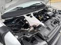 The image shows the engine compartment of a 2020 Chevrolet Express with visible engine components and a plastic cover over the engine block