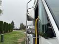 A 2012 Ford E-450 Super Duty with prominent side mirrors and a open driver side door showing a yellow handle