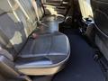 2023 RAM 3500 interior showing the rear leather seats with seatbelts and armrest compartment