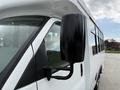 A 2013 Chevrolet Express with a focus on the side mirror showcasing its black casing and reflective surface