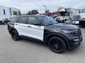 A 2021 Ford Explorer with a black and white exterior parked at a dealership featuring black wheels and a sporty design