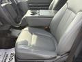 Interior of a 2011 Ford F-350 SD with a focus on the driver's side seat and center console in gray upholstery