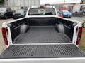 A 2011 Chevrolet Colorado pickup truck with a black rubber bed liner and a spacious, clean cargo area