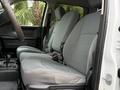 Interior of a 2013 RAM 3500 featuring two gray cloth front seats and a console in between with storage compartments